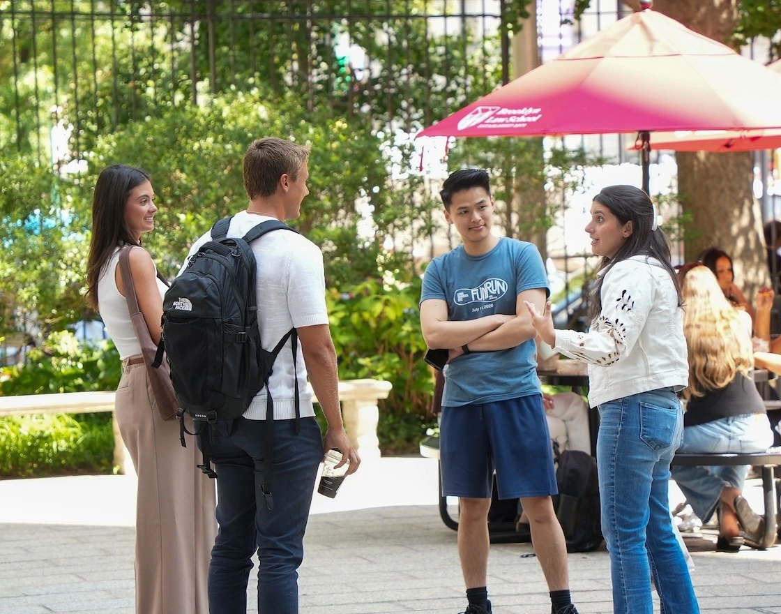 a group of four students chatting outdoors