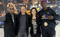 Four people pose in front of a boxing banner with two men on the left, followed by a woman and another man.