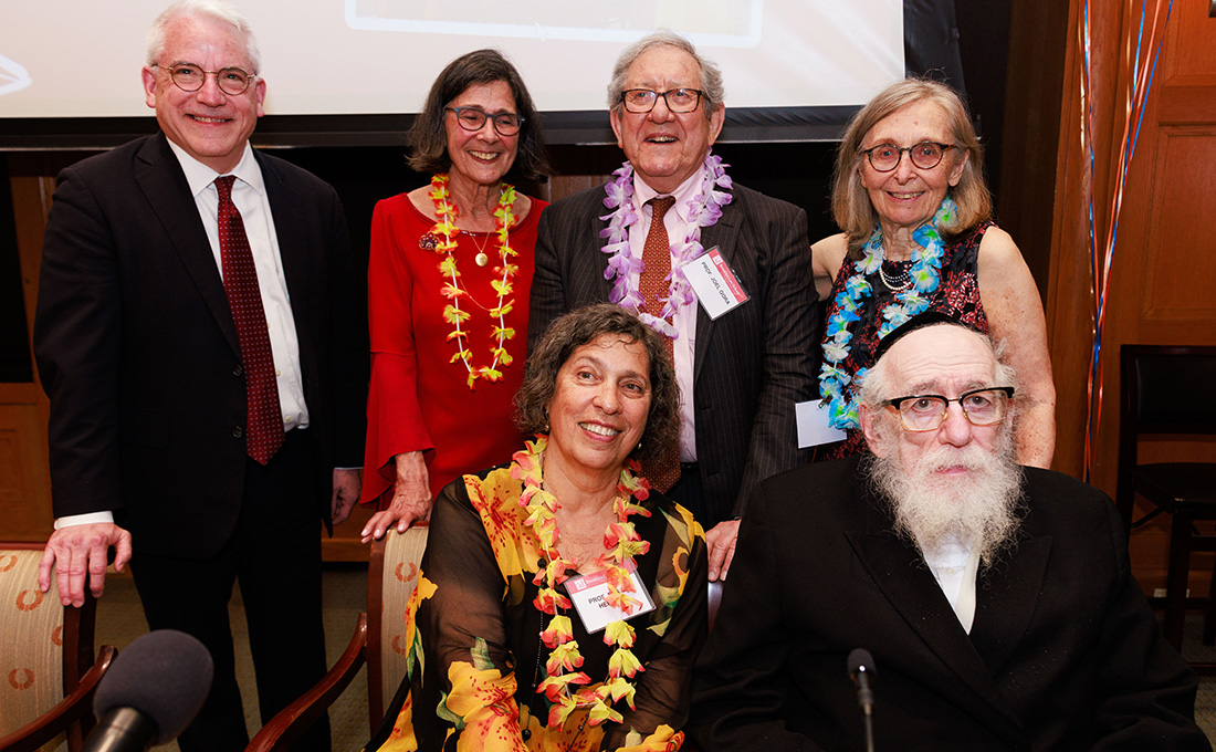 Six people -- three men and three women -- wearing formal wear and floral leis at a party.