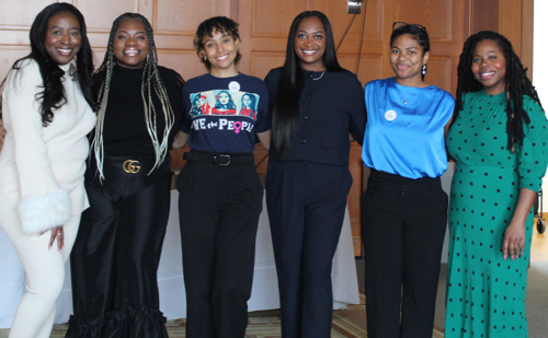 Six members of the Women of COlor Alliance pose together in a large room on the campus of Brooklyn Law School.