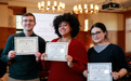 Three students holding up certificates from Brooklyn Law School.