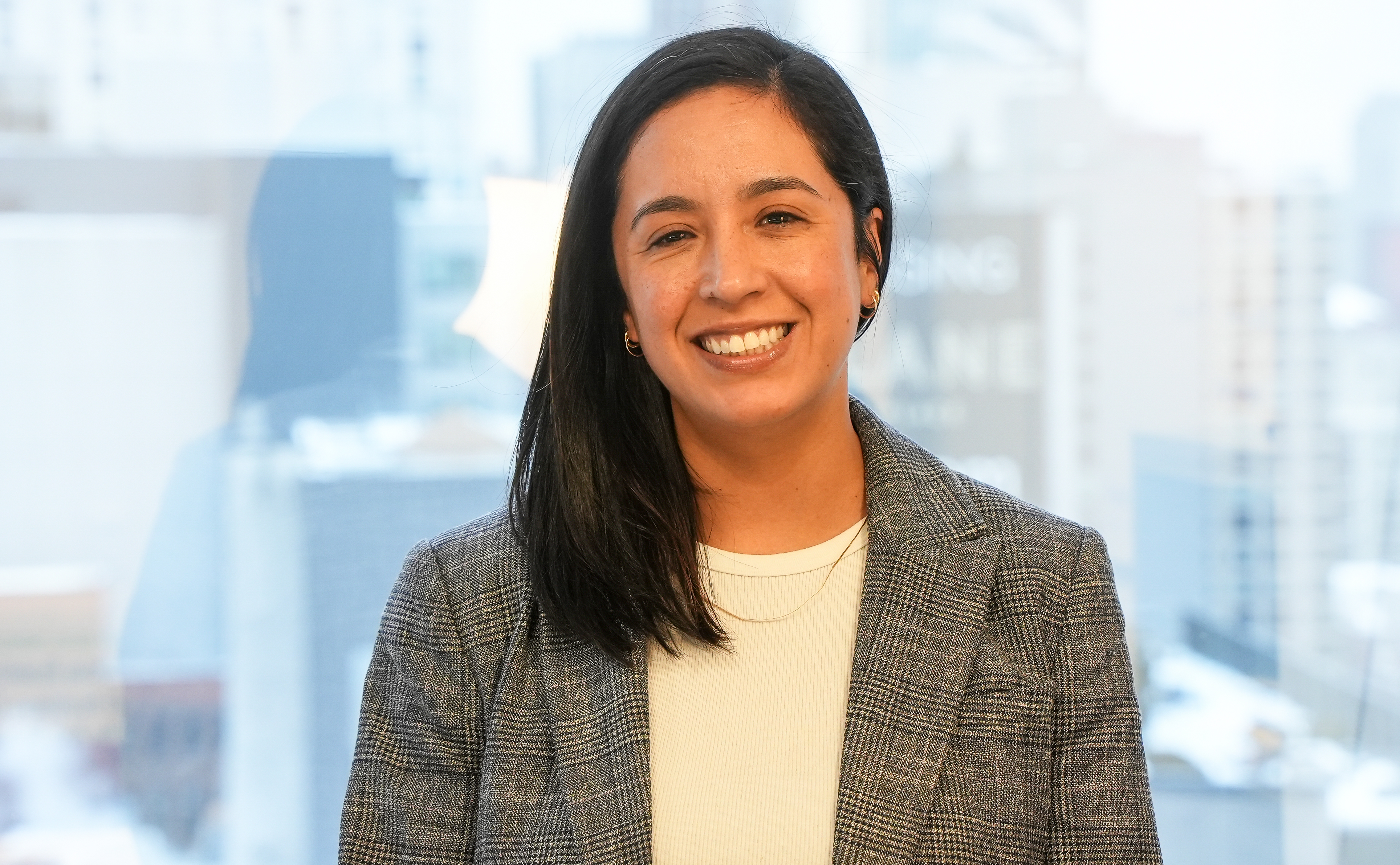 Brooklyn Law School faculty member Saskia Valencia headshot with New York City skyline visible in background.