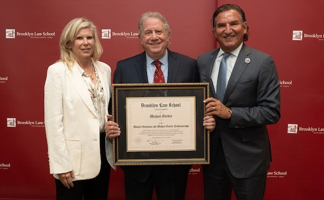 three people holding up a framed certificate