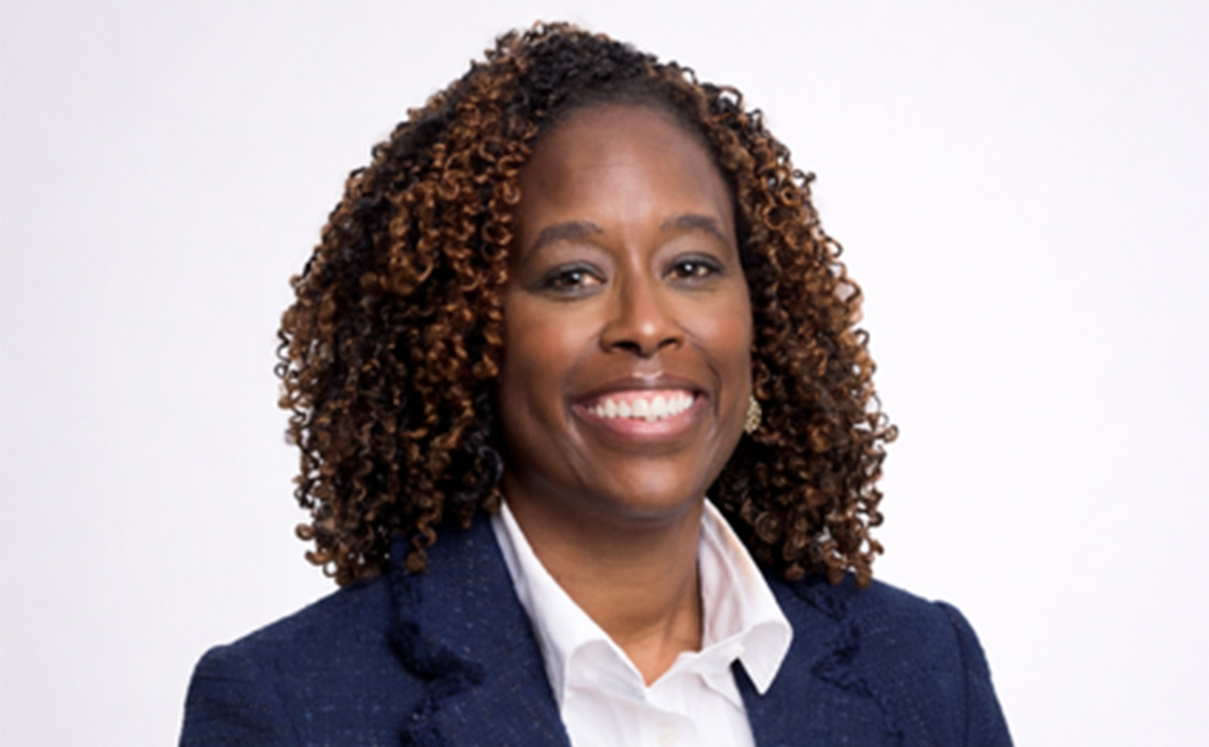 A professional headshot of a woman in a business suit.