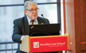 Brooklyn Law School Professor Joel Gora speaks behind a lectern with Brooklyn Law School branding.