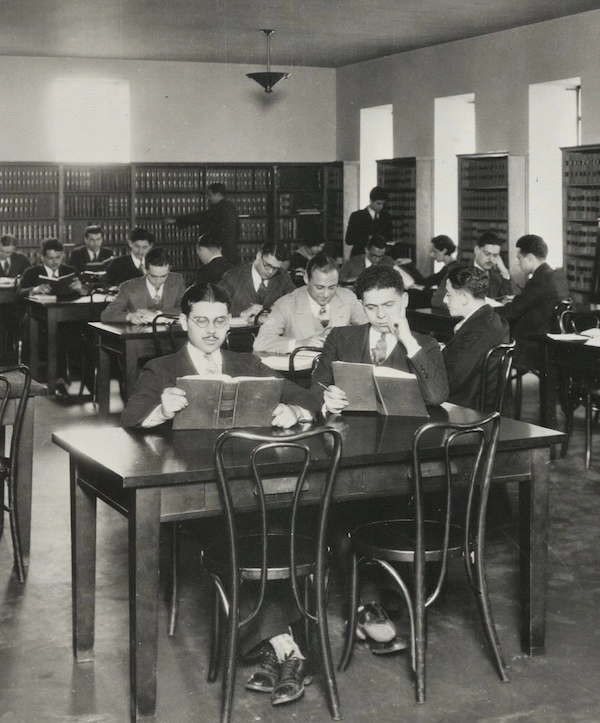 historic black & white photo of students in a library